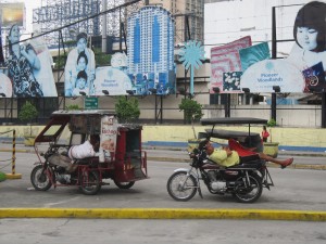 Tricycle drivers taking a break between fares on the only resting place available to them. 