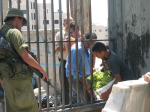 A Palestinian boy passes grapes through the bars at an Israeli checkpoint in the occupied West Bank.