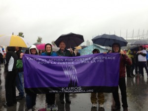KAIROS supporters and banner in the rain.
