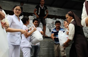 Picture 2 - Ecumenical Effort: Roman Catholic Religious Sisters, Nurses, Protestant and Roman Catholic volunteers line up at the compound of the National Council of Churches in the Philippines to pass relief goods to load a truck headed for the survivors of typhoon Yolanda . (Photo: ACT/Sandra Cox)