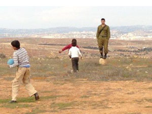 Soldier with children playing. Photo by G. Timbers