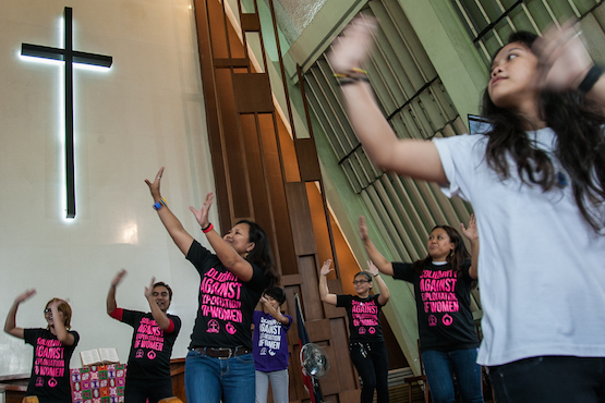 Women dance inside a Protestant church in the Philippines to dramatize calls to end discrimination against women. (Photo by Mark Saludes)