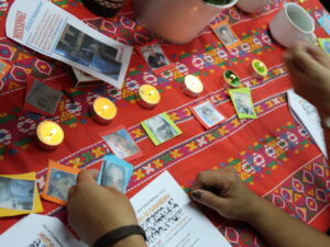 Images of human right defenders and candles on a table with decorative cloth