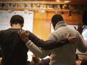 Two men praying together.