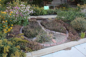 Peace symbol laid in a garden with bricks