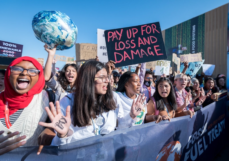 Young people marching through the venue of the United Nations climate change conference and holding up signs